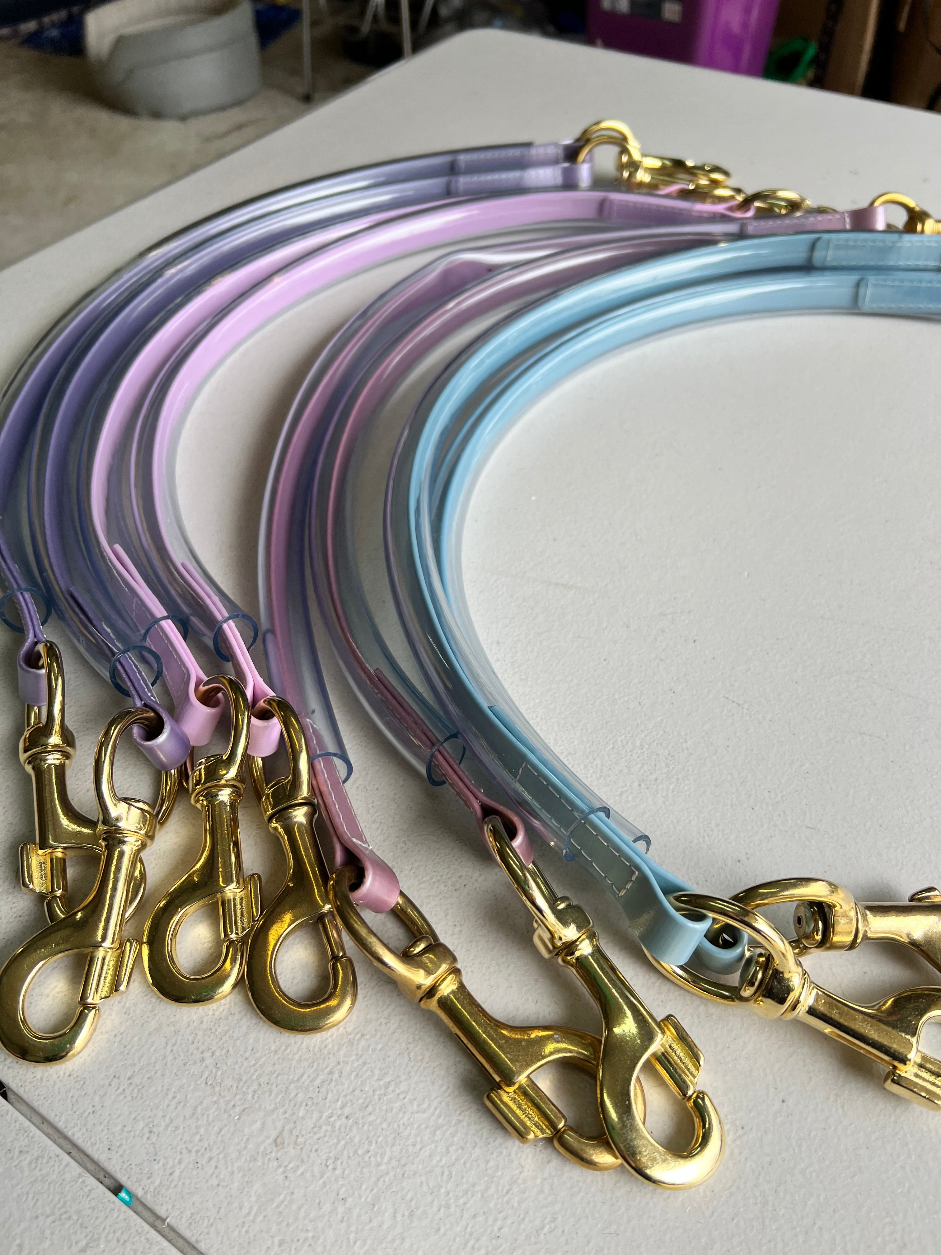 Assorted colour Biothane race day tie-ups with brass clips and clear tubing cover flat lay — SS Saddlery